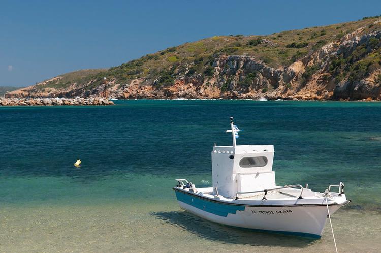a white boat Moored at the small harbour of linionas bay in kos